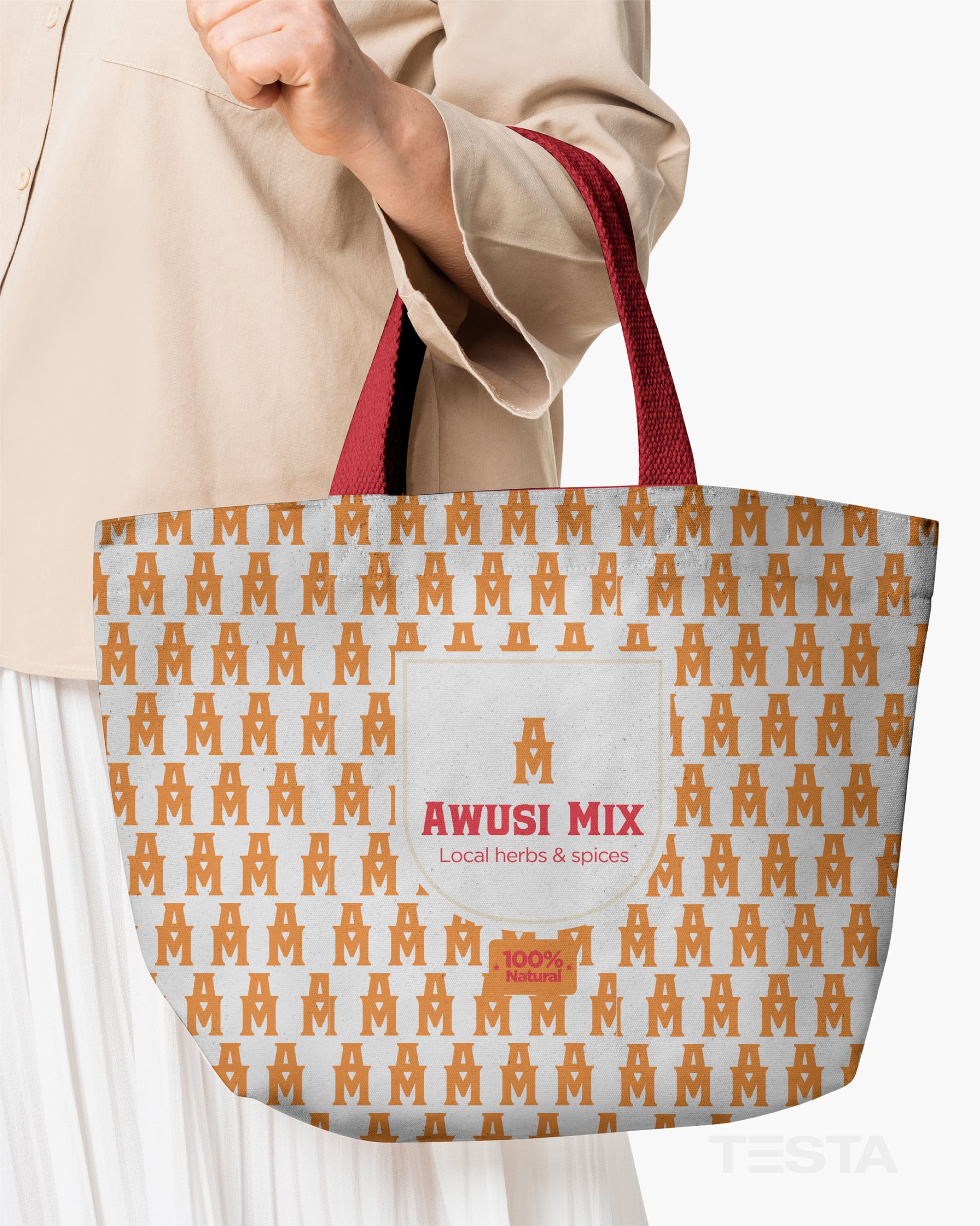 Woman carrying an Awusi Mix canvas tote in the AM monogram pattern with red handles
